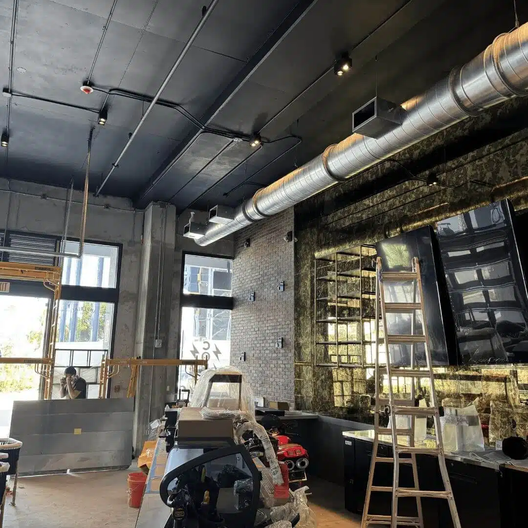 Commercial bar under construction with exposed ductwork and track lighting wiring by Xmart Power Electric.