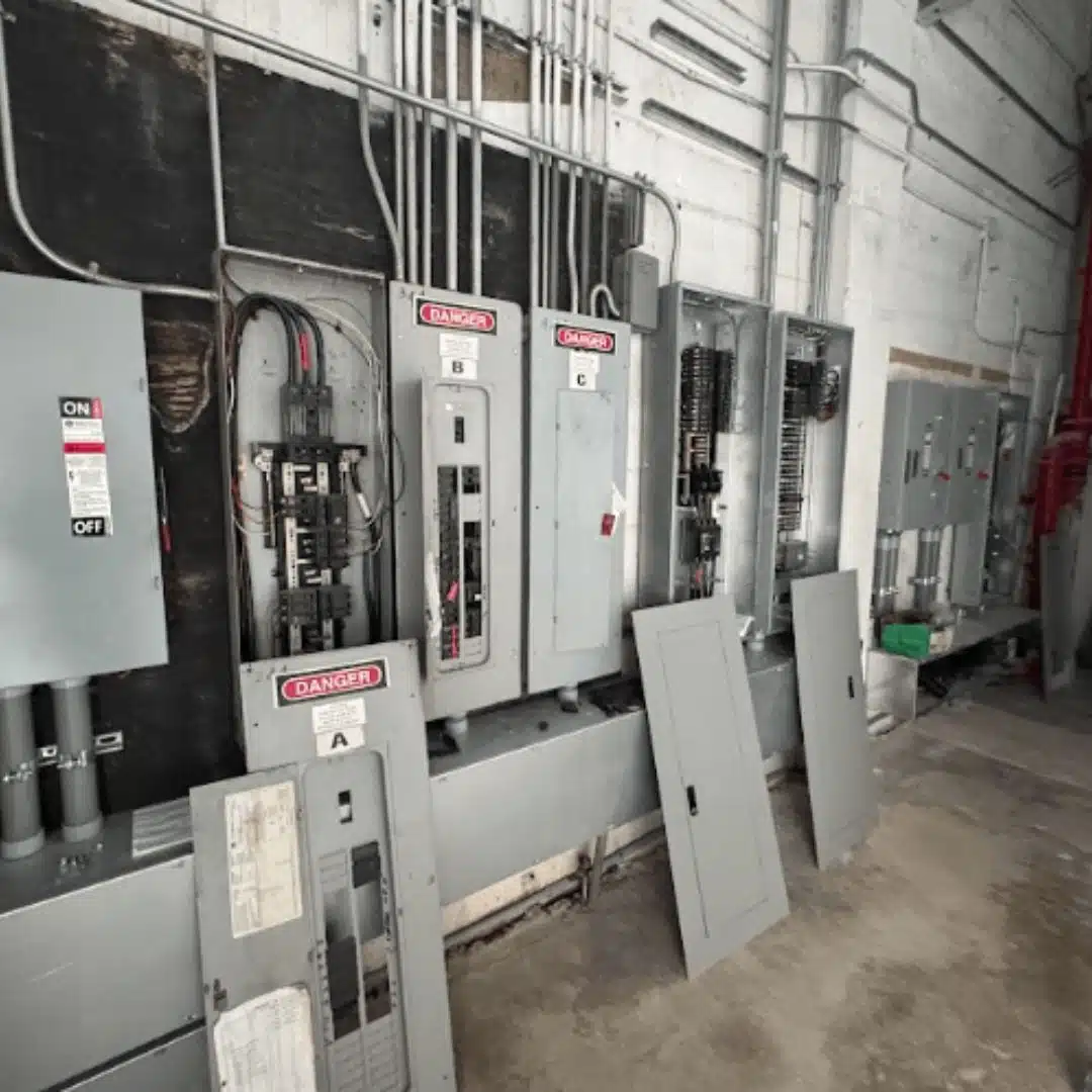 Electrical panel maintenance with exposed breakers and wiring during commercial service work in Florida.
