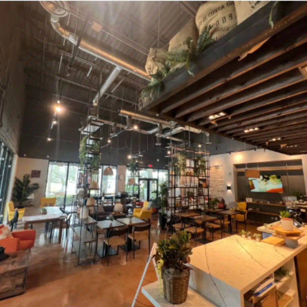 Warm and stylish café interior with decorative lighting and exposed ceiling work done by Xmart Power Electric.