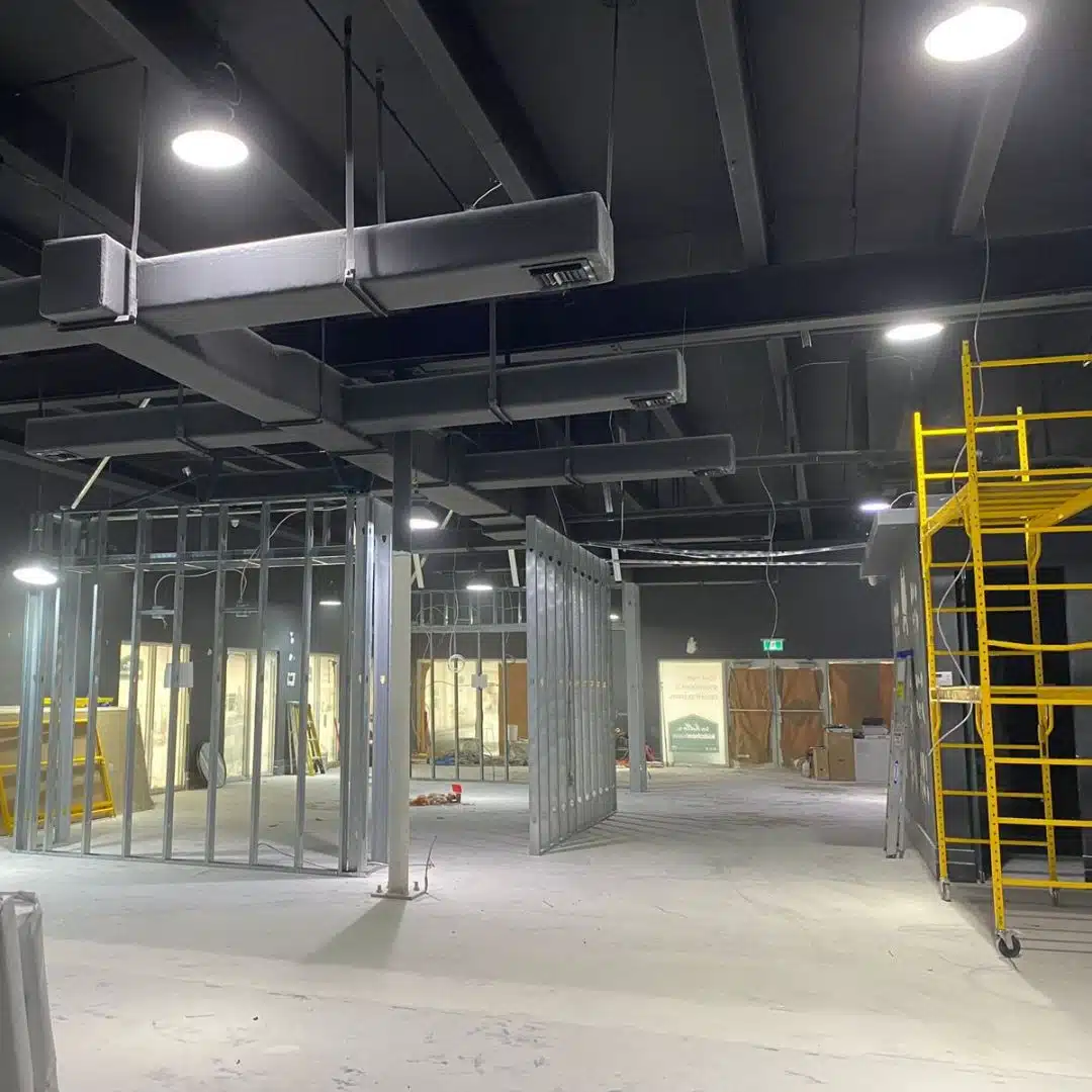 Ongoing commercial construction project with exposed framing and electrical wiring by Xmart Power Electric.
