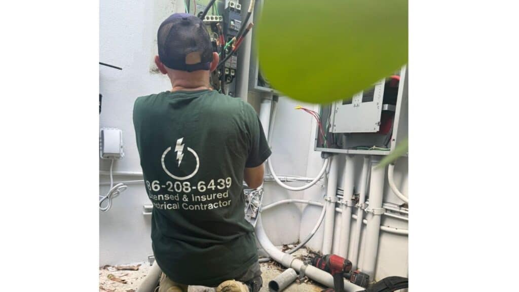 Licensed and insured XPE electrician performing expert terminal connections in an outdoor electrical service panel.