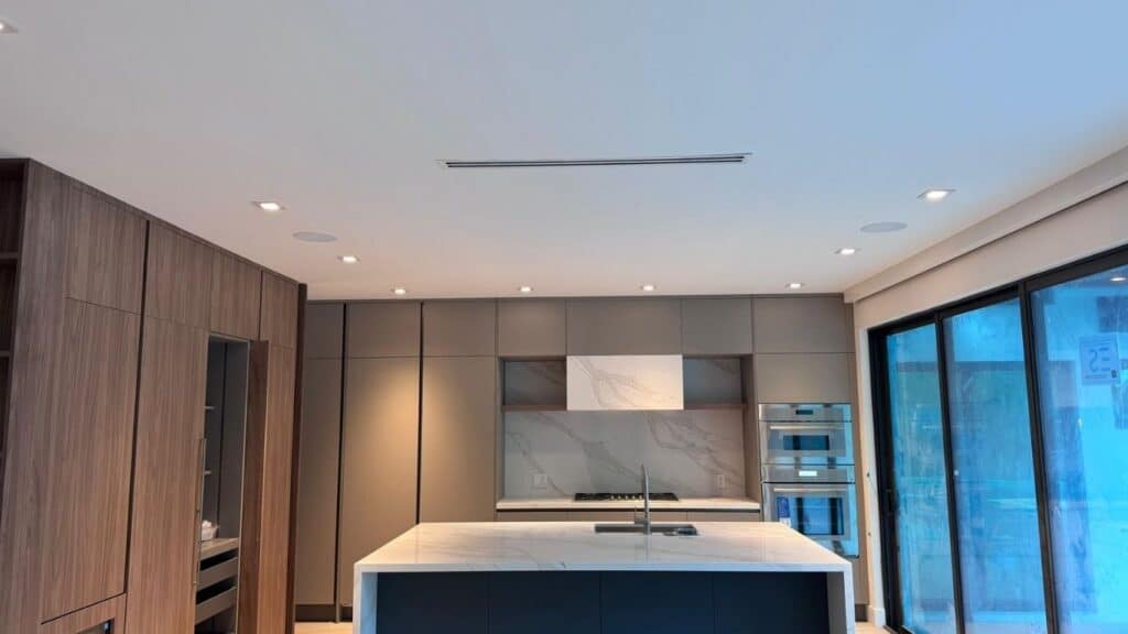 Luxury modern kitchen with marble waterfall island, custom flat-panel cabinetry, and integrated high-end ovens.