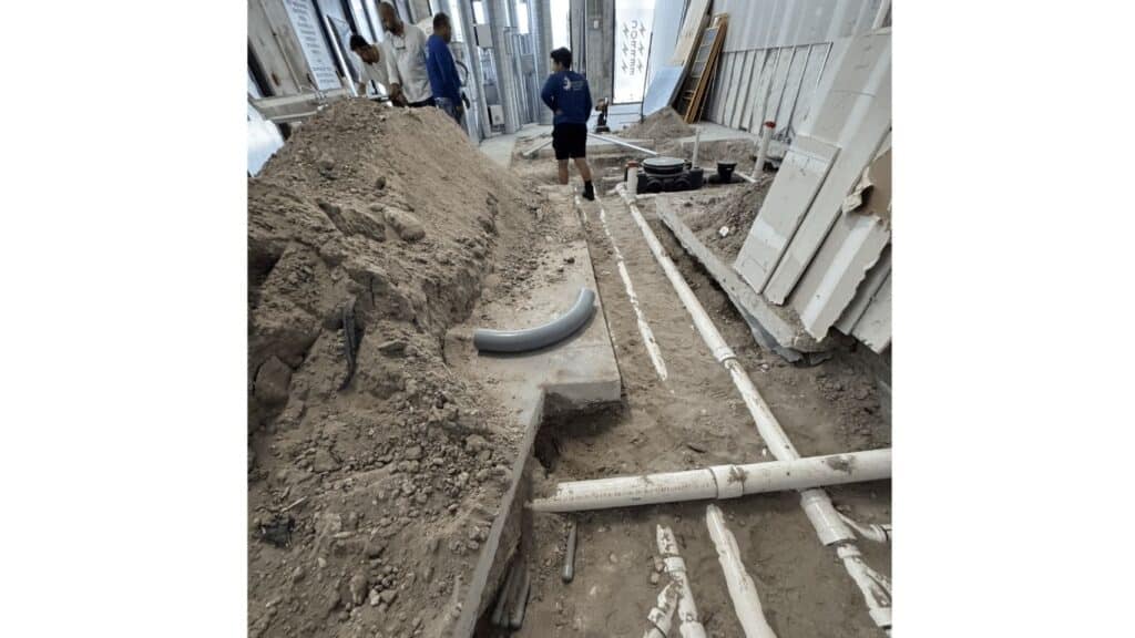 Underground PVC pipe installation and plumbing rough-in for a commercial building.