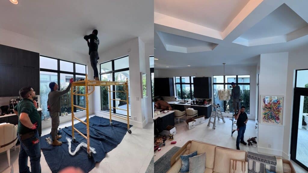 Professional electricians installing high-end pendant lights and recessed lighting in a luxury modern home with high ceilings.