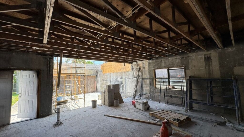 Commercial building interior with exposed wood roof trusses and concrete block walls.