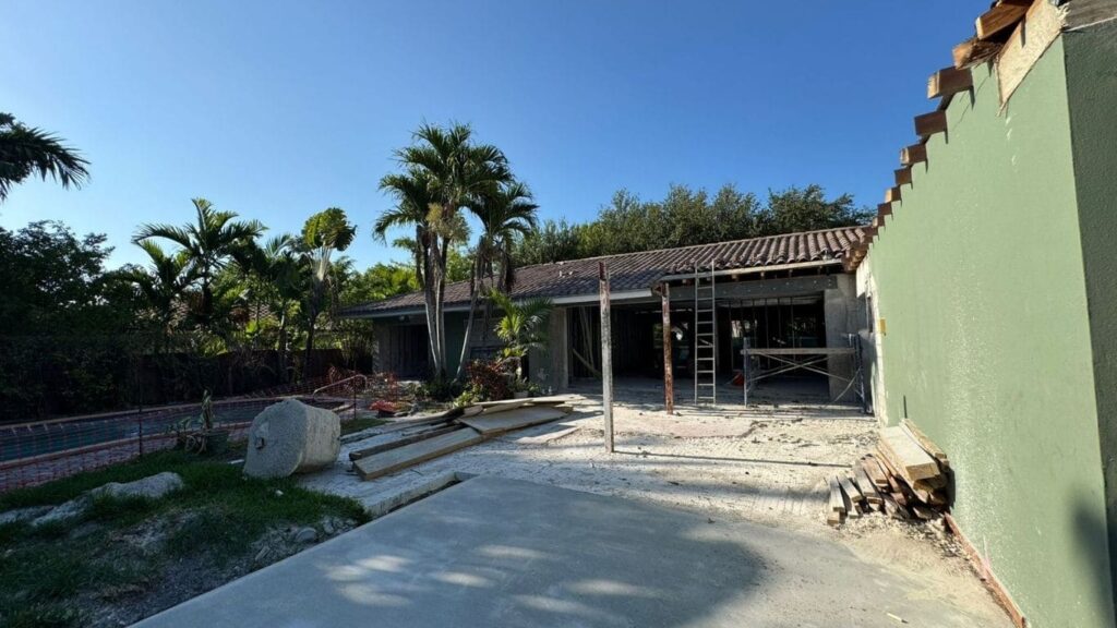 Residential backyard renovation featuring pool area construction and structural framing.