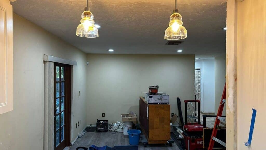 Modern kitchen lighting update with decorative glass pendant lights and recessed ceiling LEDs.