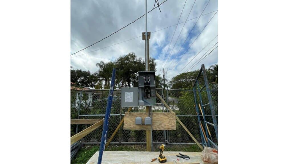 Temporary electrical power pole and meter socket installation for a residential construction site.