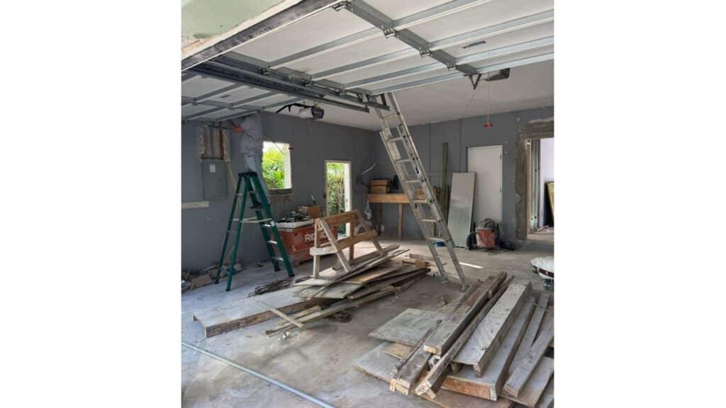 Residential garage electrical rough-in featuring main breaker panel and ceiling-mounted garage door opener.