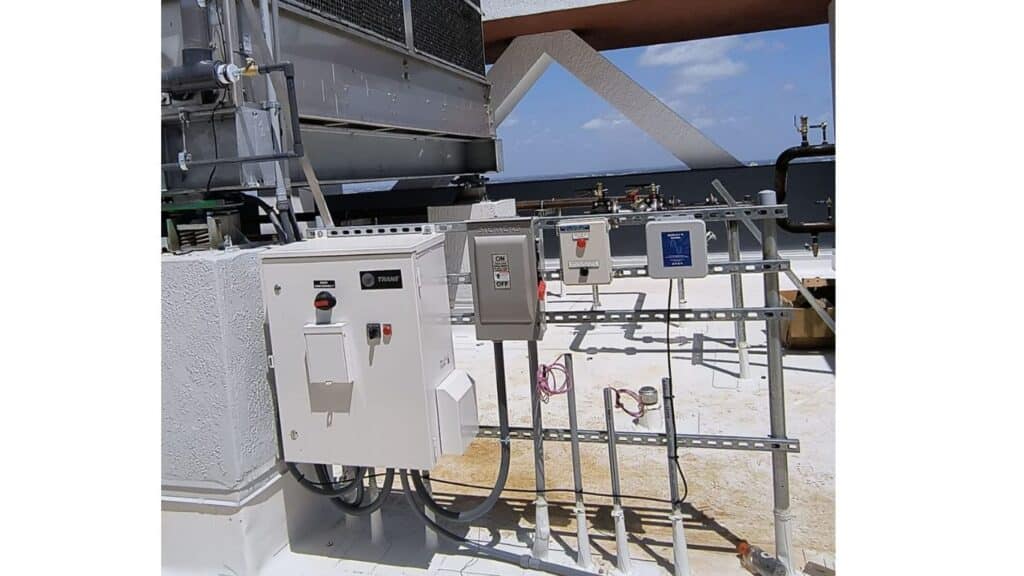 Rooftop HVAC control system installation with Trane electrical enclosures and disconnect switches.