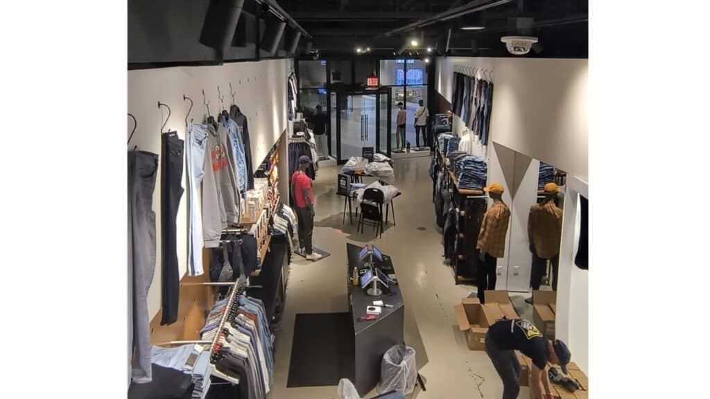 Full interior view of a modern retail clothing store with professional track lighting and custom wall displays.