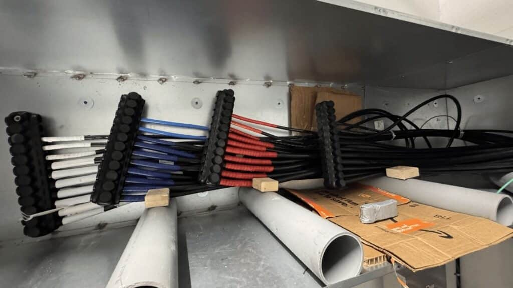 High-voltage feeder cable installation inside a large-scale electrical pull box with professional cable supports and phase identification.